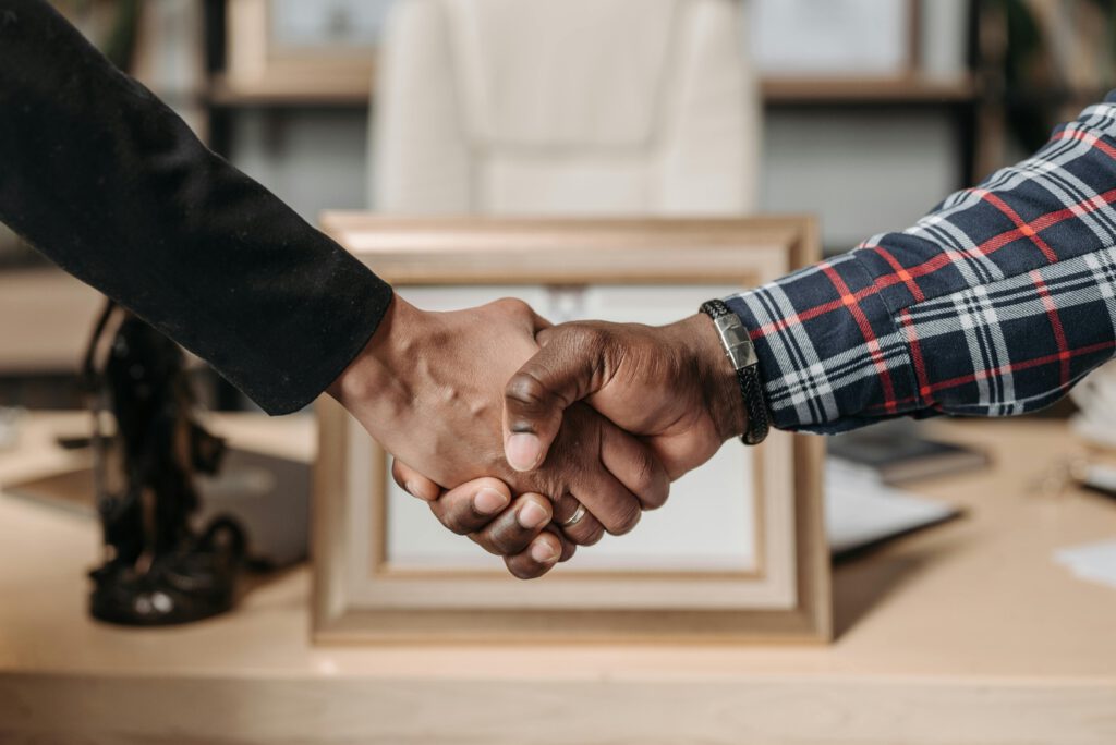 Close-up of a handshake between two professionals in an office environment.